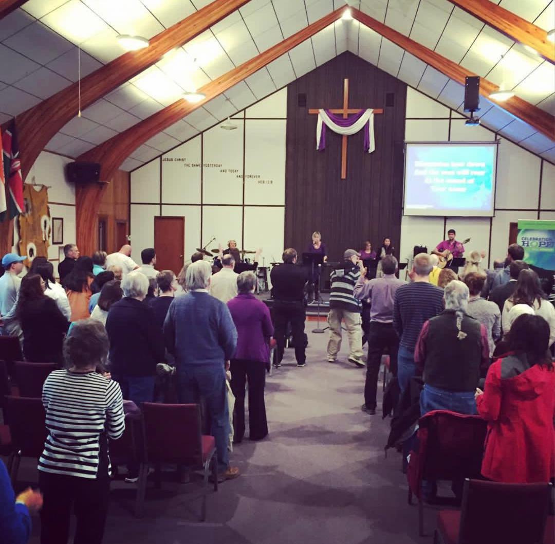 The congregation standing together in worship at Grace Fellowship